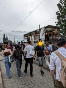 Zu sehen ist ein kleiner LKW auf der Augustusbrücke, welcher mit Plakaten zum Thema Selbstbestimmung dekoriert sind. Um den LKW herum laufen viele Menschen.